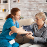 female nurse using digital blood pressure device